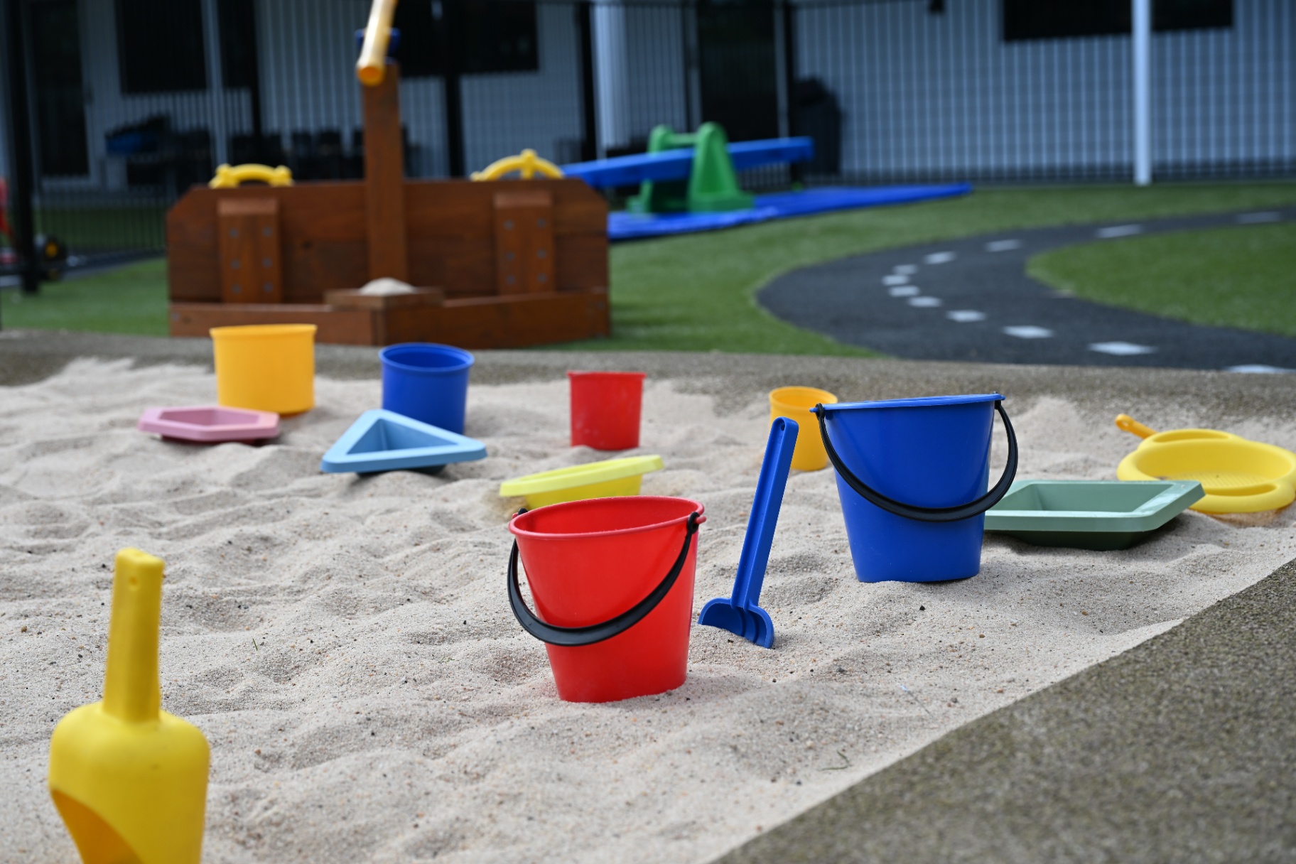 Sandpit with colourful buckets and play equipment at Mount Low