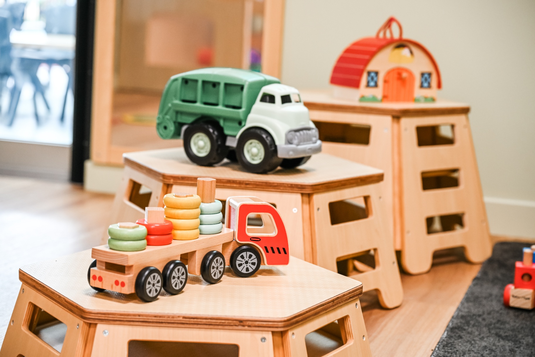Wooden toy trucks on stools in a Mount Low learning room
