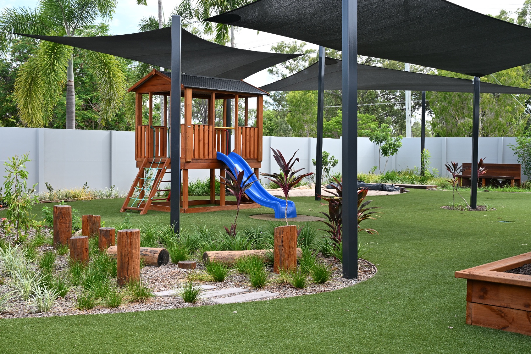 Mount Low outdoor playground with cubby house, slide and shade sails