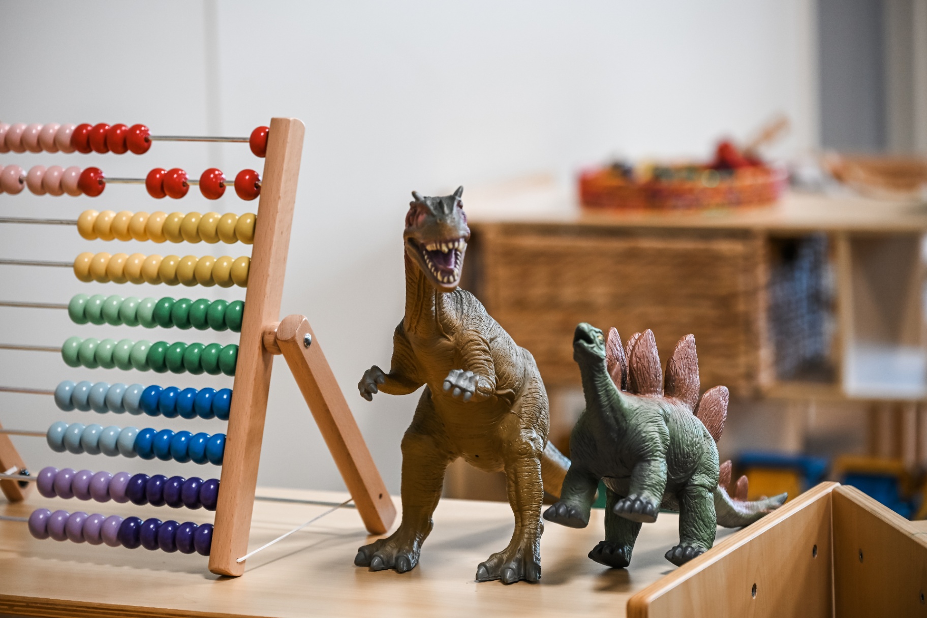 Colourful abacus and dinosaur figurines on a Mount Low table